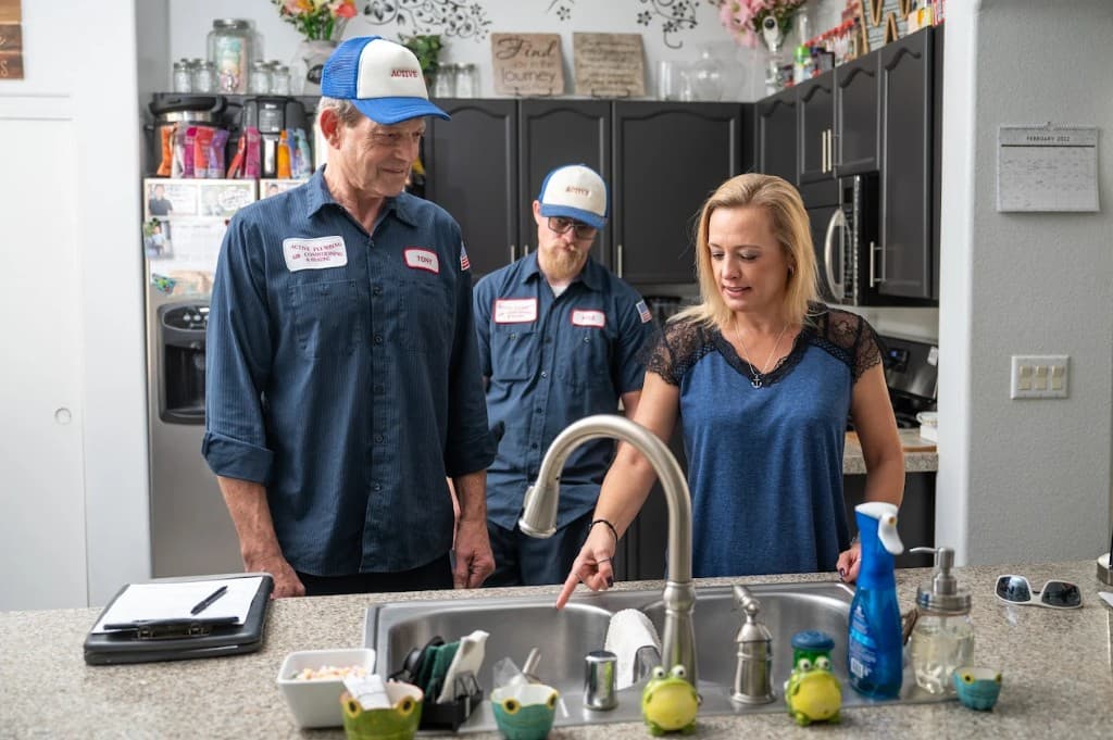 Drain & Sewer Services in Las Vegas Valley | Active Plumbing. Active Plumbing technicians consulting with a homeowner at a kitchen sink during a service visit.
